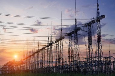 Gün batımında elektrik direkleri ve doymuş güzel gökyüzü. dağıtım, iletim ve elektrik tüketimi