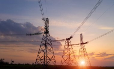 Gün batımında elektrik direkleri ve doymuş güzel gökyüzü. dağıtım, iletim ve elektrik tüketimi