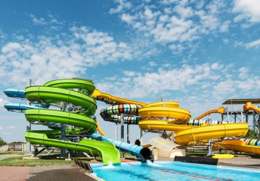 Su parkı, havuzlu parlak renkli kaydırak, yaz günü bir su parkı..