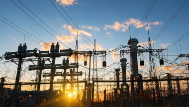 Gün batımında elektrik direkleri ve doymuş güzel gökyüzü. dağıtım, iletim ve elektrik tüketimi
