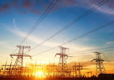 Gün batımında elektrik direkleri ve doymuş güzel gökyüzü. dağıtım, iletim ve elektrik tüketimi