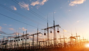 Gün batımında elektrik direkleri ve doymuş güzel gökyüzü. dağıtım, iletim ve elektrik tüketimi