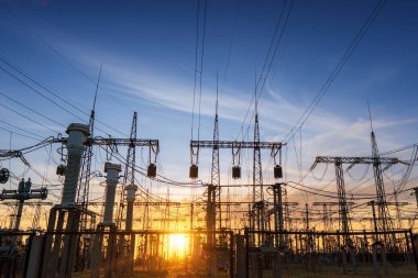 Gün batımında elektrik direkleri ve doymuş güzel gökyüzü. dağıtım, iletim ve elektrik tüketimi