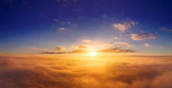 从飞机上看到一个美丽的饱满日出在乌云之上的橙色阴影 免版税图库照片