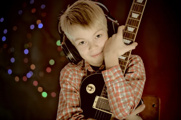 Adolescente en auriculares y guitarra escucha música —  Fotos de Stock