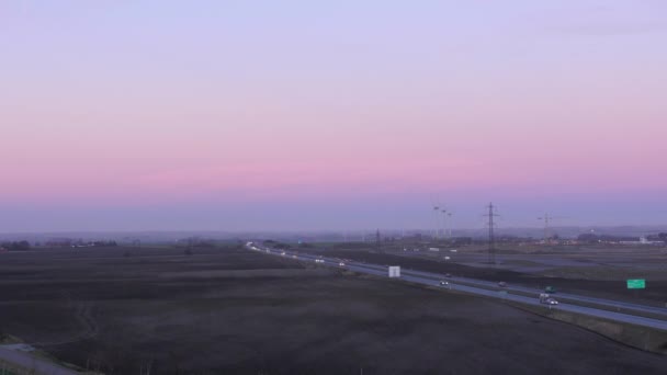 Landsbygdens trafik i solnedgången - Wind Farm + bilar — Stockvideo