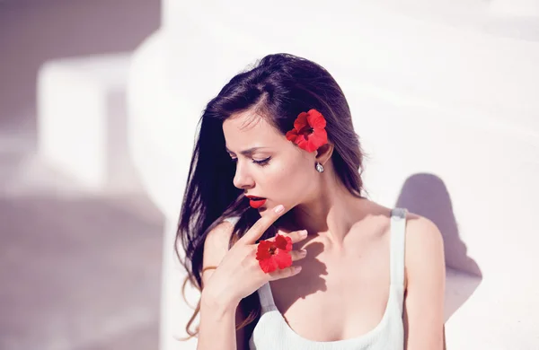 Woman posing with red flowers — Stock Photo, Image