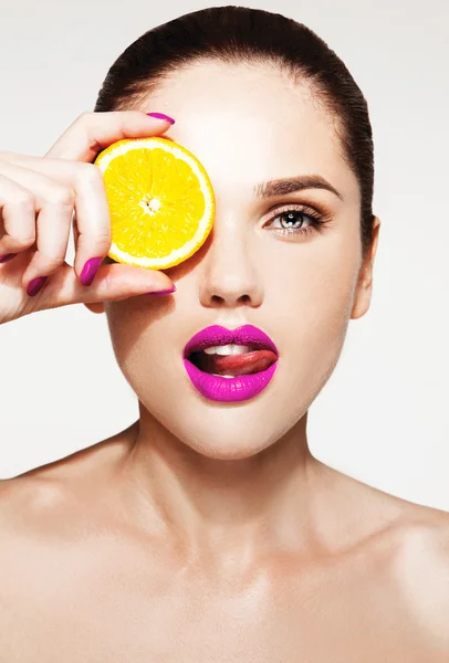 Shirtless woman holding piece of orange — Stock Photo, Image