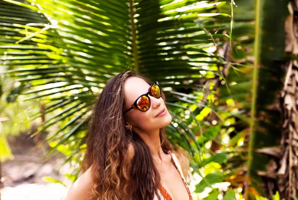 Mujer bajo la palma sobre fondo — Foto de Stock