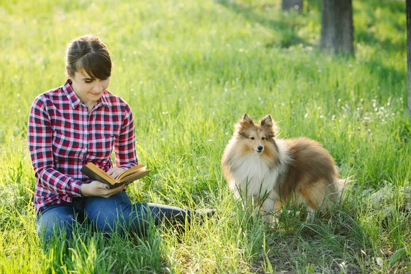 Student girl learning in nature with dog — Stock Photo, Image