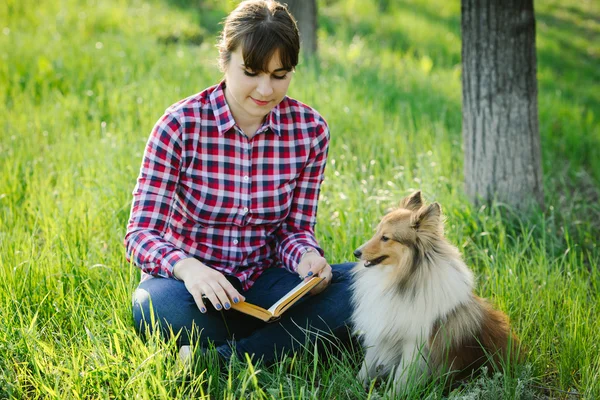 Student girl learning in nature with dog — Stock Photo, Image