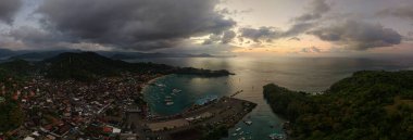 Fırtınalı Padangbai Bali limanı, alacakaranlıkta teknelerle liman, liman ve teknelerin olduğu dramatik alacakaranlık sahnesi.