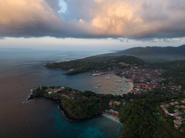 Padangbai 'de sakin bir sahil akşamı, sakin bir köy ve engebeli uçurumların sakin bir liman manzarası.