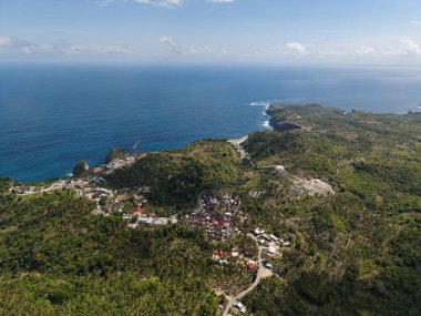 Sahil bereketli bir köy, sakin bir sahil köyü. Limanı ve bol yeşilliği var. Nusa Penida Kelingking Plajı Bali. 