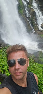 Heyecan verici ve büyüleyici bir selfie... Yeşillik içinde nefes kesici bir şelale... doğa ile çevrili yeşil bir ortam...