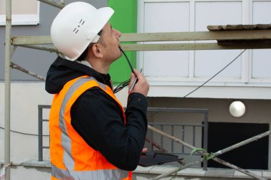 Güvenlik mühendisi inşaat alanındaki iskeleyi inceliyor. İnşaat işlerine erişim sağlıyorum. Sağlık ve Güvenlik Müfettişi.