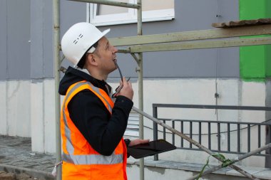 Güvenlik mühendisi inşaat alanındaki iskeleyi inceliyor. İnşaat işlerine erişim sağlıyorum. Sağlık ve Güvenlik Müfettişi.