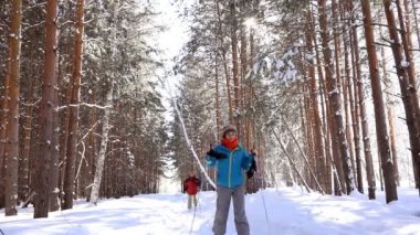 İki kadın Kayak, kış çam ormanda yürüyüş yakın