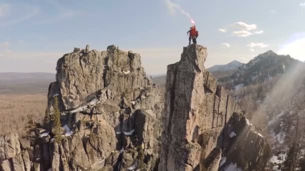 Dois alpinistas no topo de um penhasco, tocha na mão, fotografia aérea — Vídeo de Stock