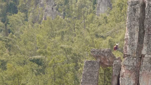 Arrampicata ragazza giù dalla scogliera su una corda — Video Stock