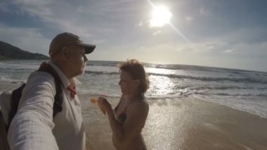 Woman Rubs Sunscreen Face of a Man. Tropical Beach.