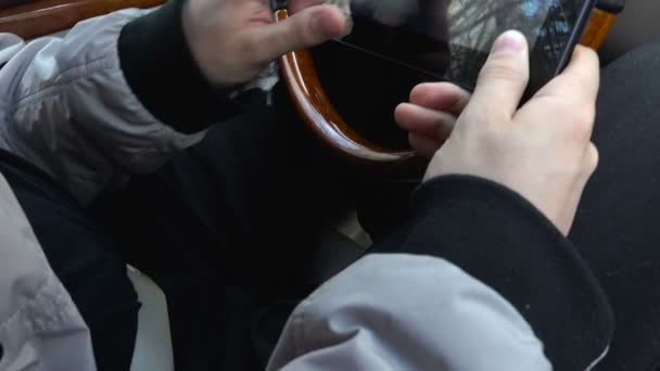 Молодой человек забирает письмо на планшете в машине — стоковое видео