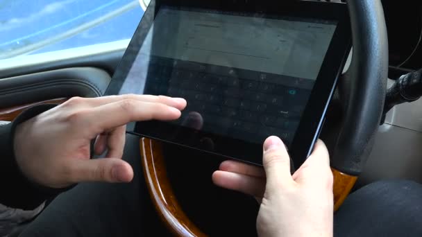 Jovem trabalhando em um tablet no carro — Vídeo de Stock