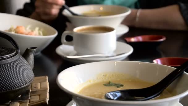 Almuerzo en un restaurante japonés. Manos de mujer con una cucharada de sopa de queso . — Vídeos de Stock