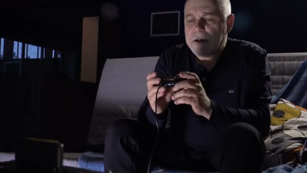 Hombre adulto con una consola de juegos en un café de habitación oscura con pasión Keen juego de ordenador — Vídeo de stock