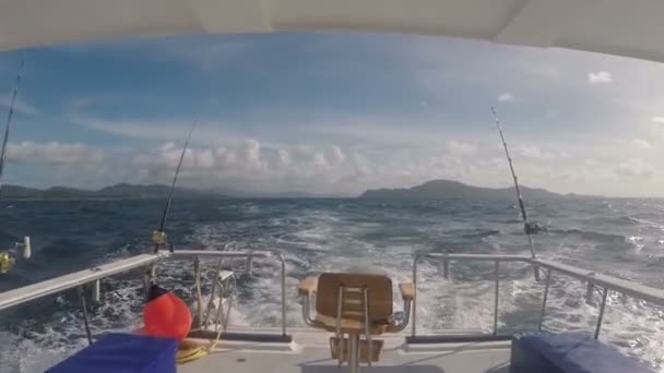 水の晴れた日にスロー回転海釣り用ボートの船尾からのオーシャン ビュー — ストック動画