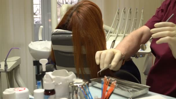 Νεαρή γυναίκα σε μια καρέκλα διαδικασίας Οδοντιατρική Οδοντίατρος, γιατρό και νοσοκόμα κατά την εργασία — Αρχείο Βίντεο