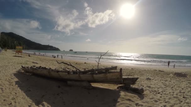 Океан заливает старую лодку, дети играют в море — стоковое видео