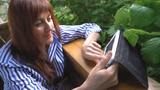 Žena v zahradě pracoval na tabletovém počítači. — Stock video