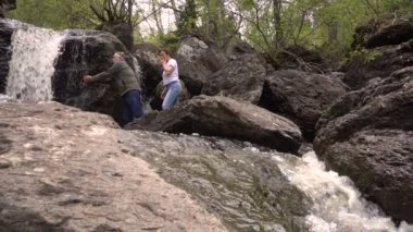 Çift erkek ve kadın bir şelale içme su birbirlerine eğleniyor sıçrama