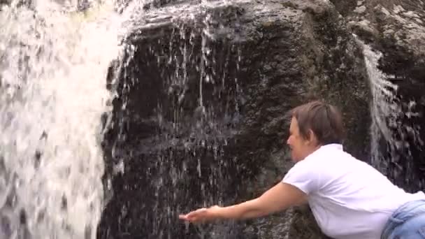 Mujer se lava con agua limpia de una cascada — Vídeos de Stock