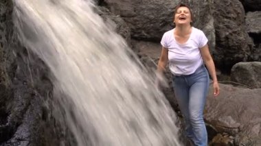 Kadın onun şelale eğlenceli gülmek şelale dağ nehir temiz su yıkar