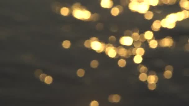 Reflexões abstratas do Bokeh do ouro na superfície da água — Vídeo de Stock