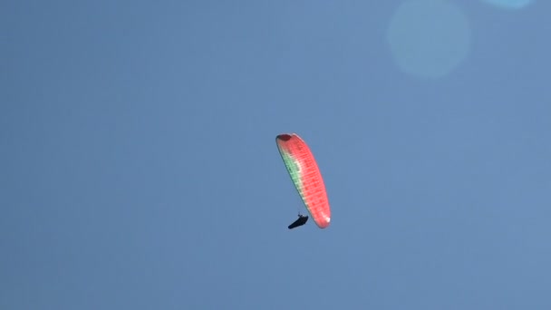 Gleitschirmflug vor einem Hintergrund aus schönen Wolken und Sonnenblenden. Sommer, sonniger Tag. — Stockvideo