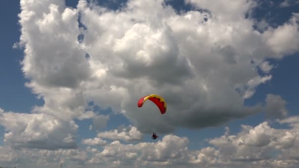 Aterrizaje del parapente sobre un fondo de nubes cúmulos — Vídeo de stock