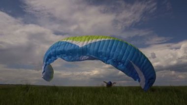 Yamaç paraşütü eğitim acemi sporcu yeryüzünde. Yamaçparaşütü kanat açma.