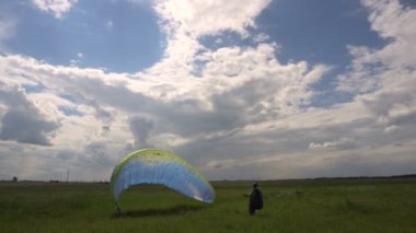 Yamaç paraşütü eğitim acemi sporcu yeryüzünde. Yamaçparaşütü kanat açma.