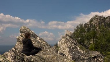 Kadın bir dağın üzerinde meditasyon. Yaz güneşli gün.