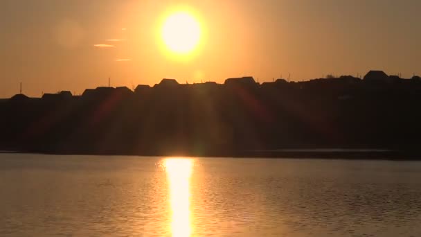 湖の日の出。平屋の農家の背景のシルエット. — ストック動画