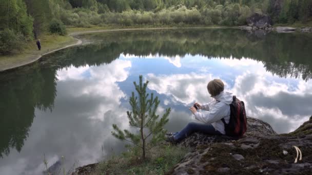 Touriste femme dans le fond du lac à la recherche de photos sur un smartphone . — Video