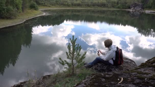 Touriste femme dans le fond du lac à la recherche de photos sur un smartphone . — Video