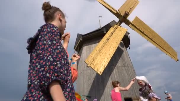 Rosja, Magnitogorsk.01.09.2016. Rosyjski festiwal folklorystyczny. Tańce na tle wiatraków jest. — Wideo stockowe