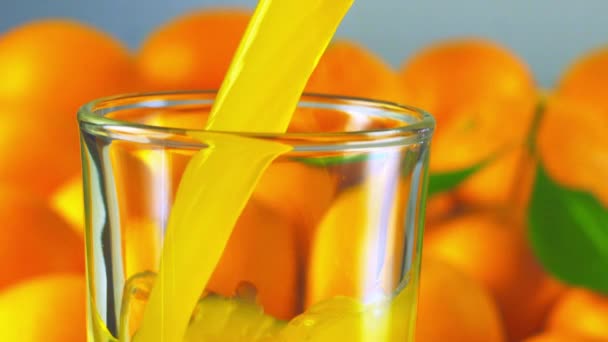 Апельсиновый сок наливают в стакан — стоковое видео