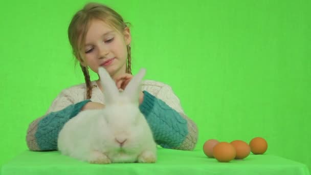 Κορίτσι με ένα λευκό κουνέλι σε μια πράσινη οθόνη — Αρχείο Βίντεο