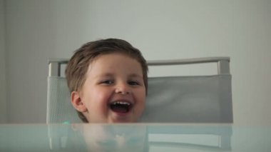 Küçük çocuk yemek masada oturuyor