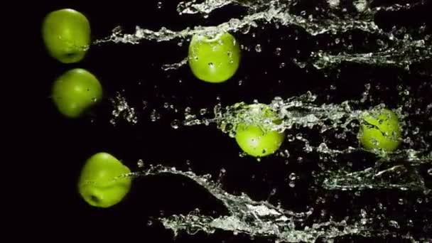 Grüner Apfel mit Spritzern Wasser — Stockvideo